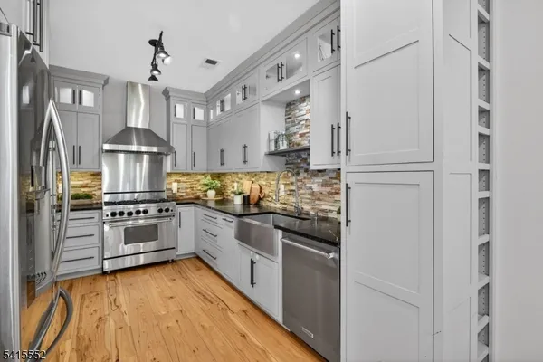 a kitchen with kitchen island granite countertop a sink cabinets and stainless steel appliances