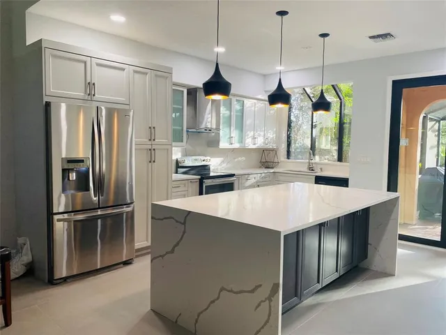 a kitchen with stainless steel appliances granite countertop a refrigerator a sink and a stove