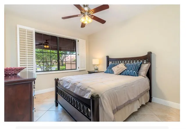 a bedroom with a bed a dresser and a chandelier