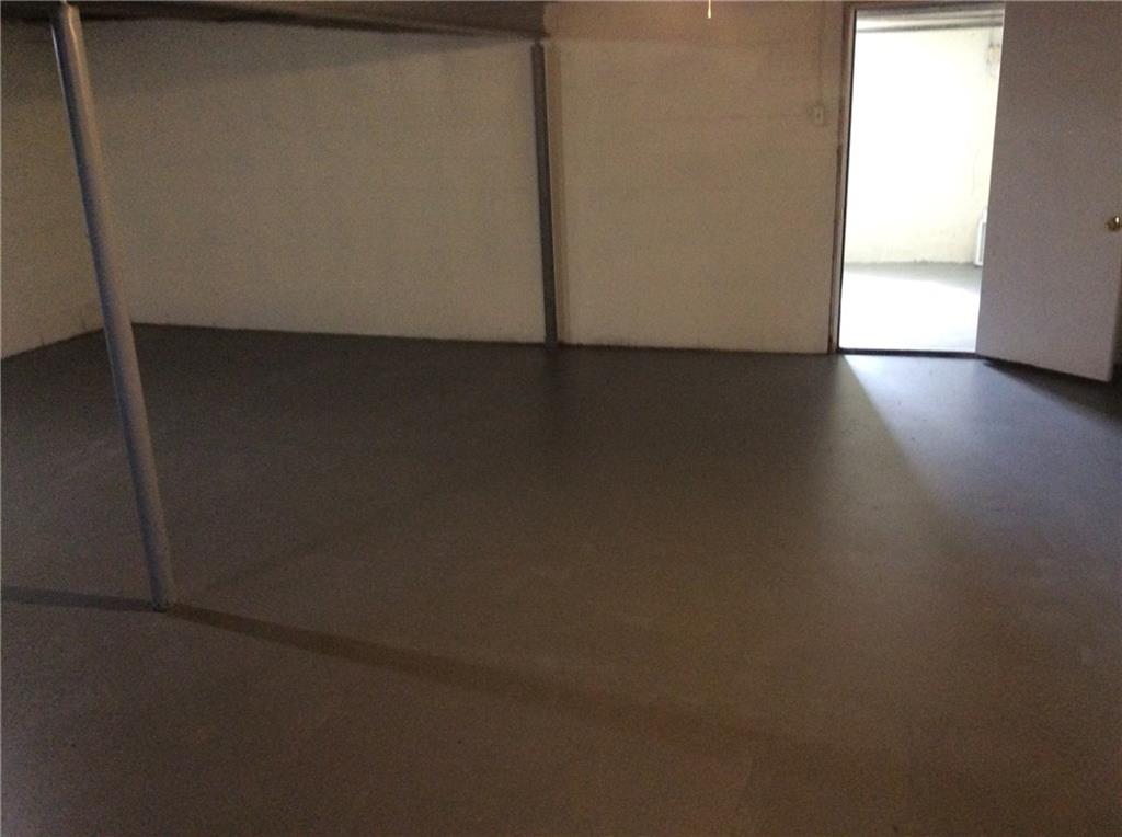 Large clean basement looking toward the open door to the garage.