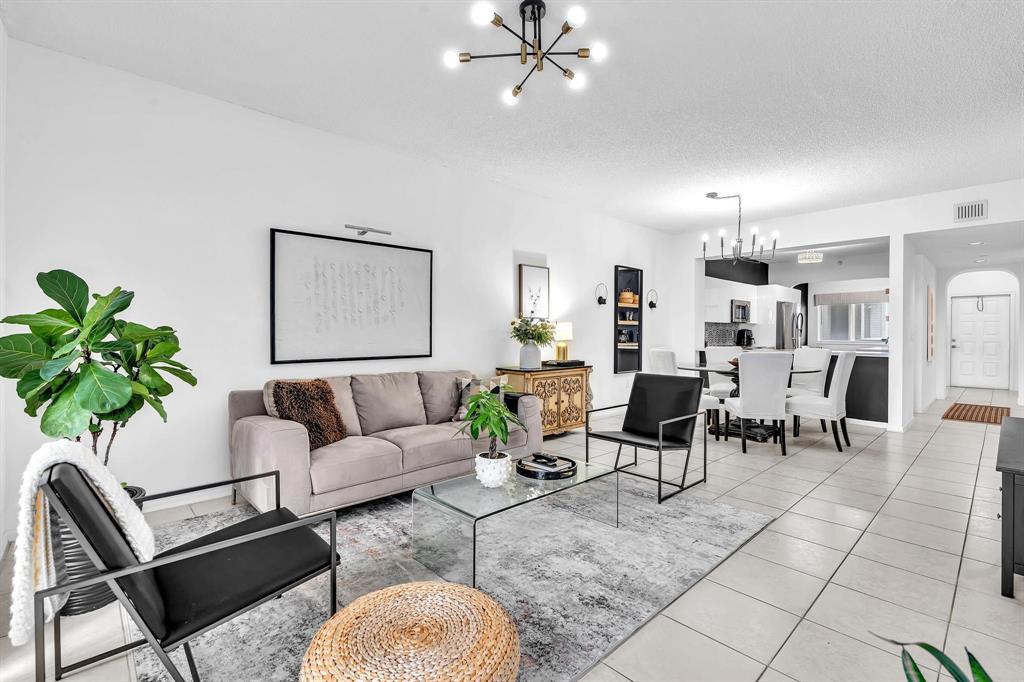 7775 Southampton Terrace, Unit 405 Tamarac, FL 33321 - Photo 20 of 82 a living room with furniture and a chandelier