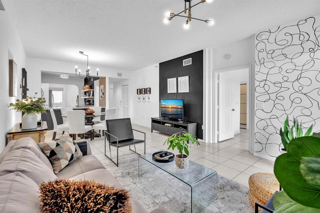 7775 Southampton Terrace, Unit 405 Tamarac, FL 33321 - Photo 25 of 82 a living room with furniture a chandelier and a rug