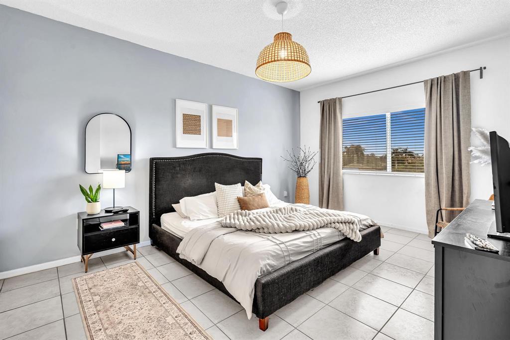 7775 Southampton Terrace, Unit 405 Tamarac, FL 33321 - Photo 27 of 82 a bedroom with a bed and a dresser