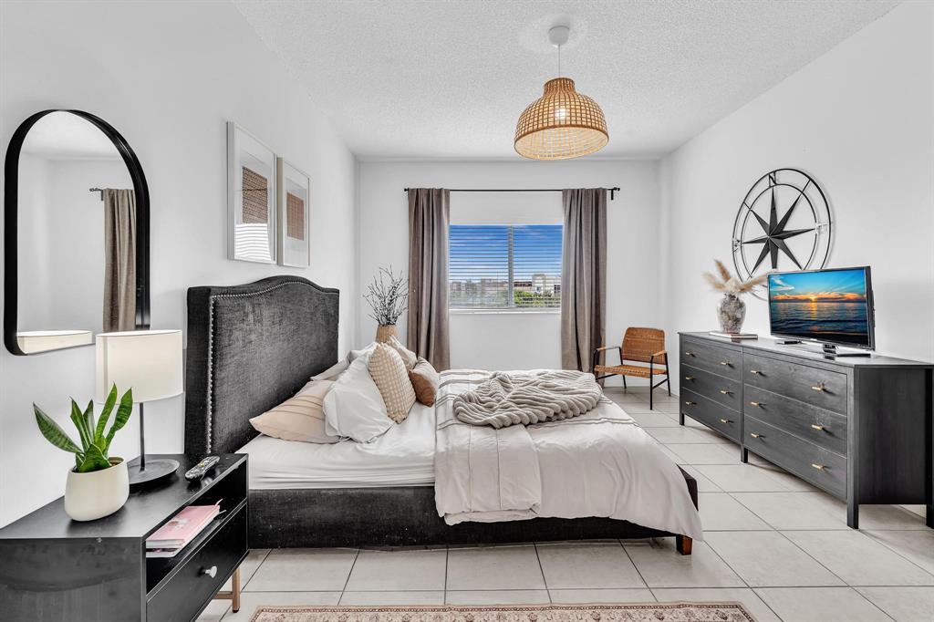 7775 Southampton Terrace, Unit 405 Tamarac, FL 33321 - Photo 28 of 82 a bedroom with a bed and ceiling fan