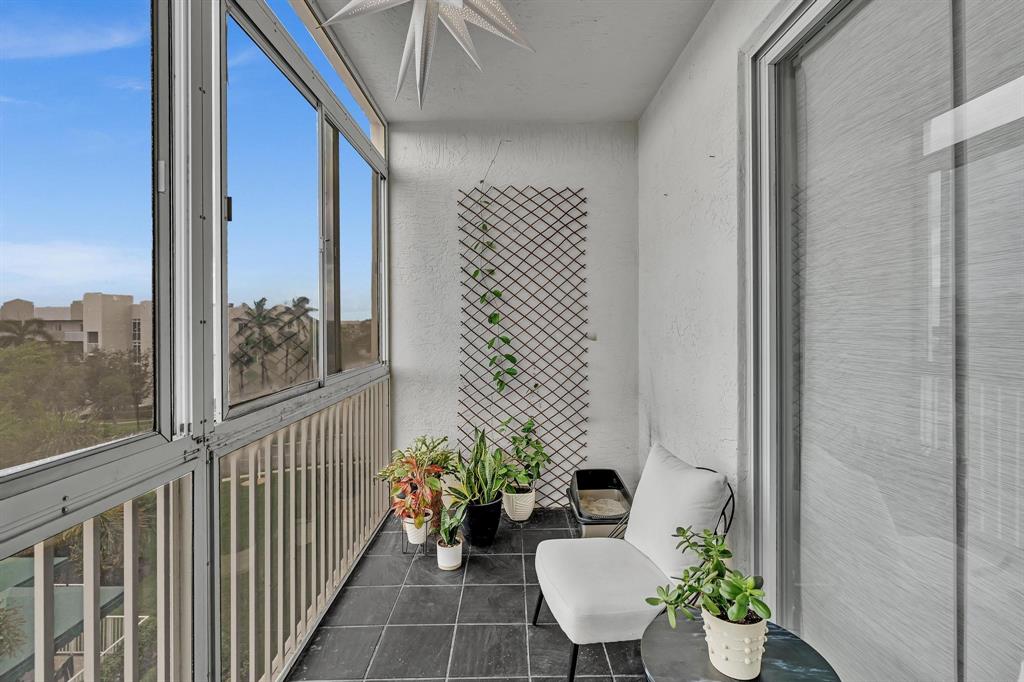 7775 Southampton Terrace, Unit 405 Tamarac, FL 33321 - Photo 47 of 82 a view of a balcony with chairs and a potted plant