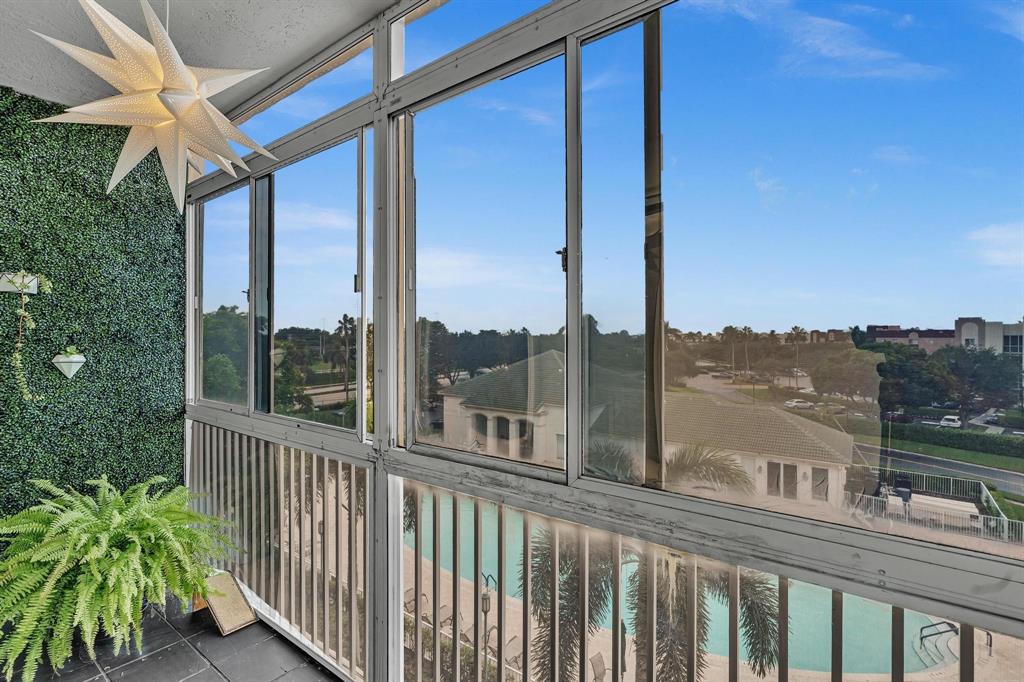 7775 Southampton Terrace, Unit 405 Tamarac, FL 33321 - Photo 49 of 82 a view of a balcony with a floor to ceiling window and wooden fence