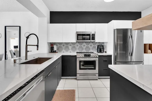 a kitchen with stainless steel appliances a refrigerator sink and cabinets