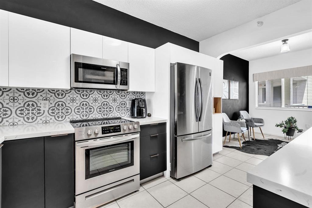 7775 Southampton Terrace, Unit 405 Tamarac, FL 33321 - Photo 8 of 82 a kitchen with stainless steel appliances granite countertop a refrigerator stove and microwave