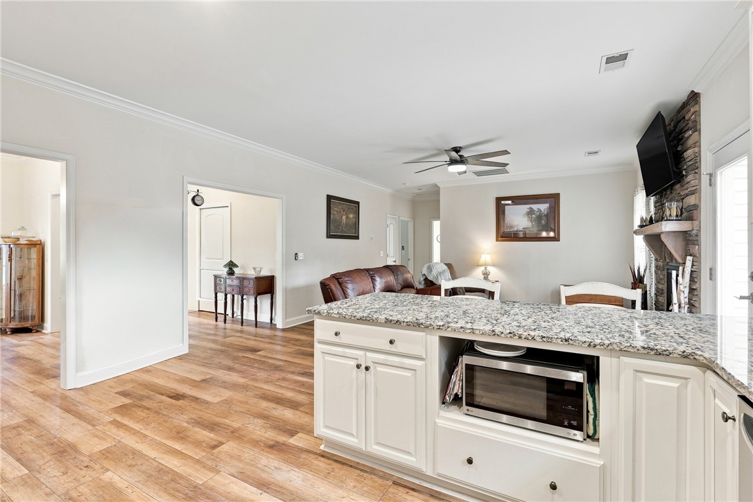 525 Shirley Store Road Anderson, SC 29621 - Photo 8 of 46 An open layout highlights the transitions between the stone-counter kitchen and warm wood-floored living spaces.