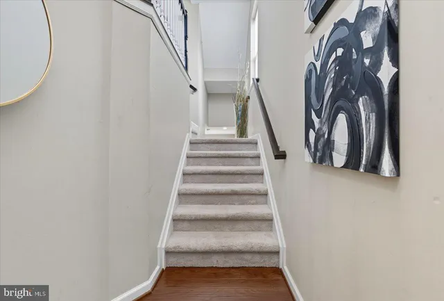 a view of staircase with wooden floor and white walls