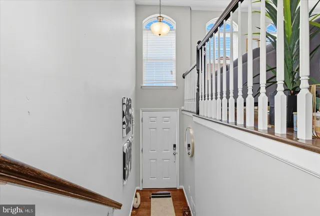 a view of staircase with railing and a chandelier