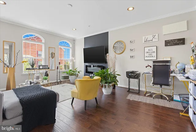 a living room with furniture a flat screen tv and a table