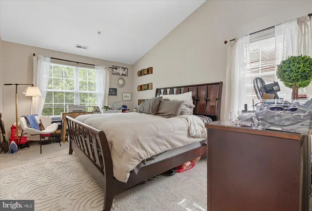 a bed sitting in a bedroom next to a window