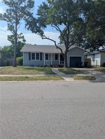 a yellow house with a large tree in front of it