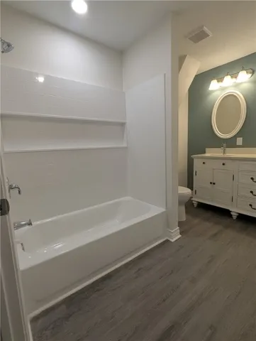 a bathroom with a sink mirror vanity and bathtub