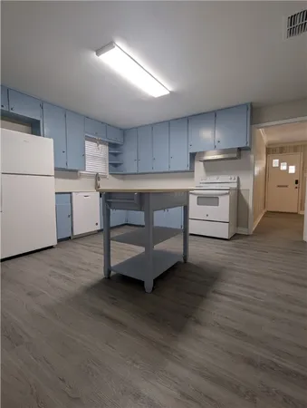 a kitchen with a refrigerator sink and cabinets