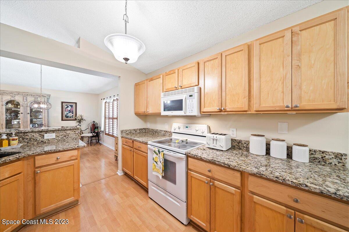 2190 Spring Creek Circle Palm Bay, FL 32905 - Photo 15 of 73 a kitchen with stainless steel appliances granite countertop a stove a sink and white cabinets