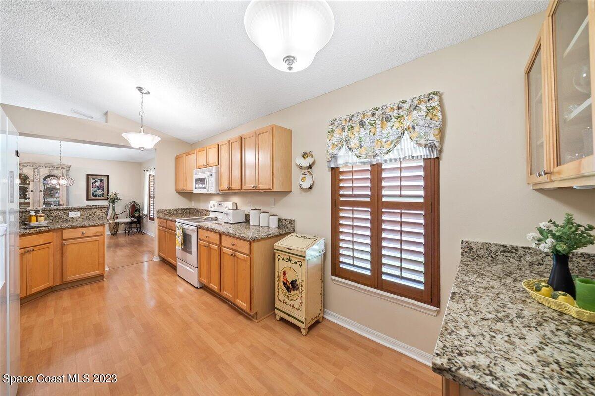 2190 Spring Creek Circle Palm Bay, FL 32905 - Photo 19 of 73 a kitchen with stainless steel appliances granite countertop a stove a sink dishwasher and a refrigerator with wooden floor
