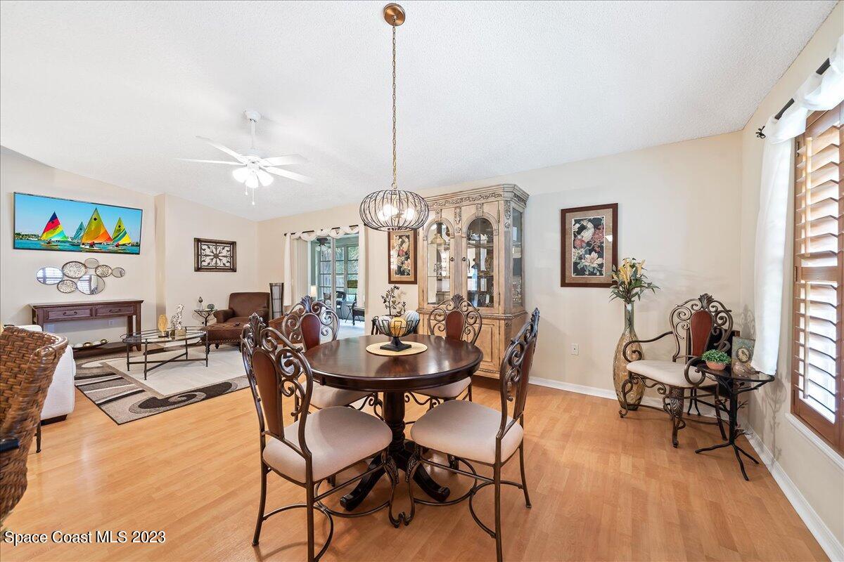 2190 Spring Creek Circle Palm Bay, FL 32905 - Photo 22 of 73 a view of a dining room with furniture a chandelier and wooden floor
