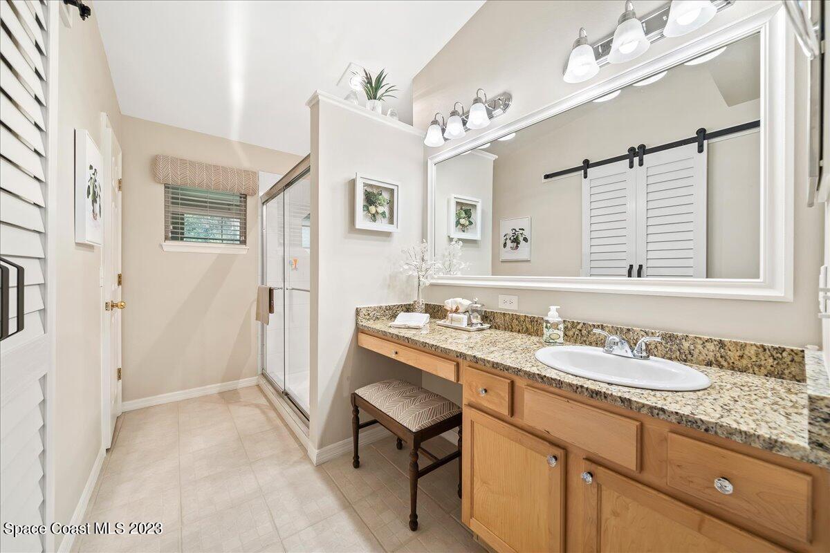 2190 Spring Creek Circle Palm Bay, FL 32905 - Photo 28 of 73 a bathroom with a granite countertop sink a mirror and a shower