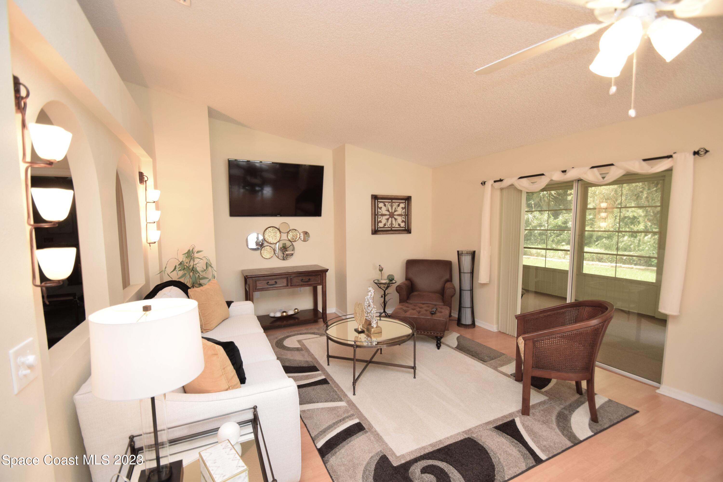 2190 Spring Creek Circle Palm Bay, FL 32905 - Photo 64 of 73 a living room with furniture a fireplace and a flat screen tv