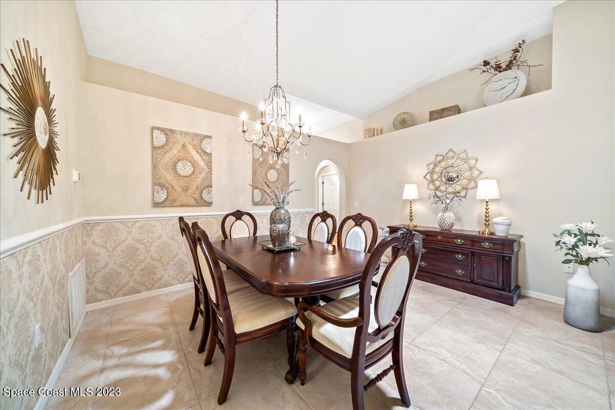 2190 Spring Creek Circle Palm Bay, FL 32905 - Photo 7 of 73 a dining room with furniture a chandelier and window
