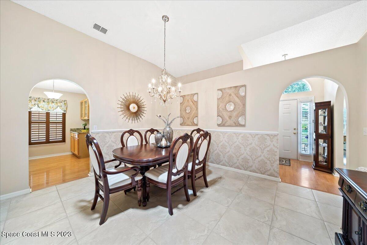 2190 Spring Creek Circle Palm Bay, FL 32905 - Photo 9 of 73 a dining room with furniture a chandelier and window