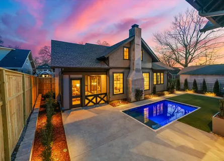 a living room with couch chandelier and fireplace