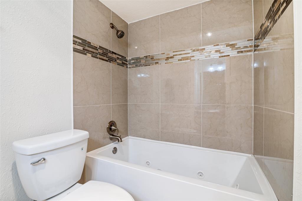 7706 Swiss Way Rowlett, TX 75089 - Photo 15 of 21 Full bath featuring tiled shower surround by a jetted soaking tub.