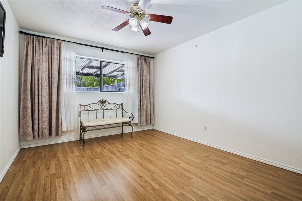 7706 Swiss Way Rowlett, TX 75089 - Photo 17 of 21 Versatile bedroom or flex space with wood-style flooring , ceiling fan, and large window.