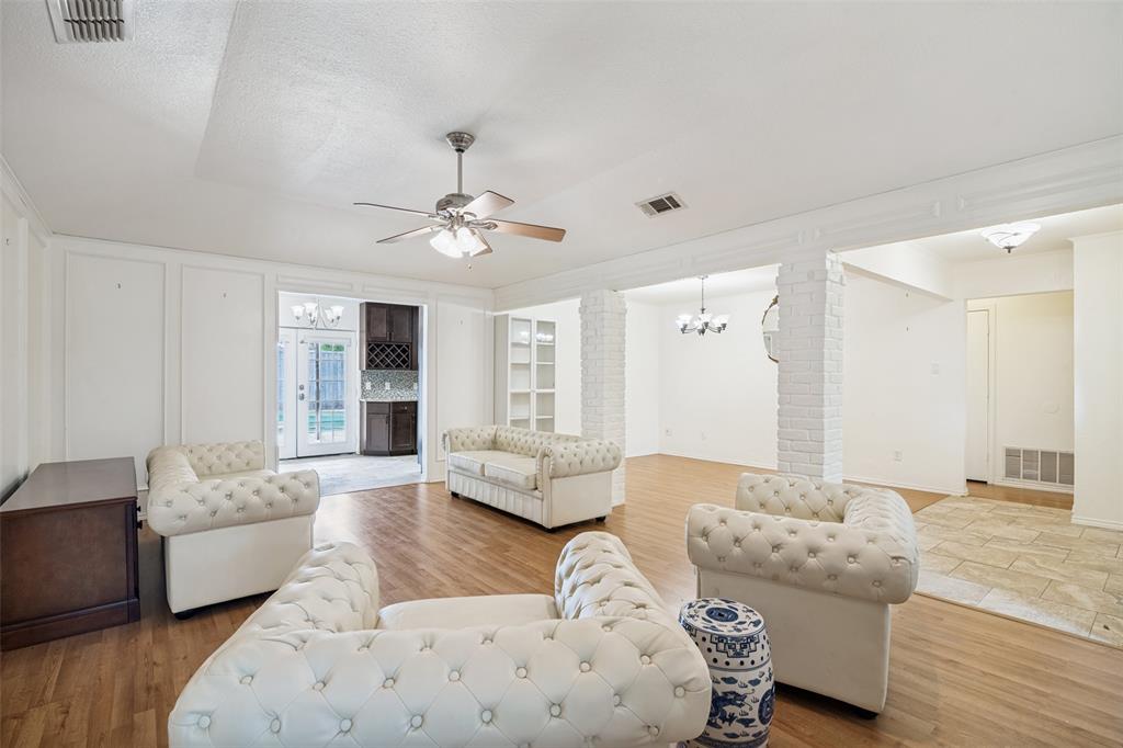 7706 Swiss Way Rowlett, TX 75089 - Photo 8 of 21 Living room area has an open layout connecting seamlessly to dining and additional living spaces.