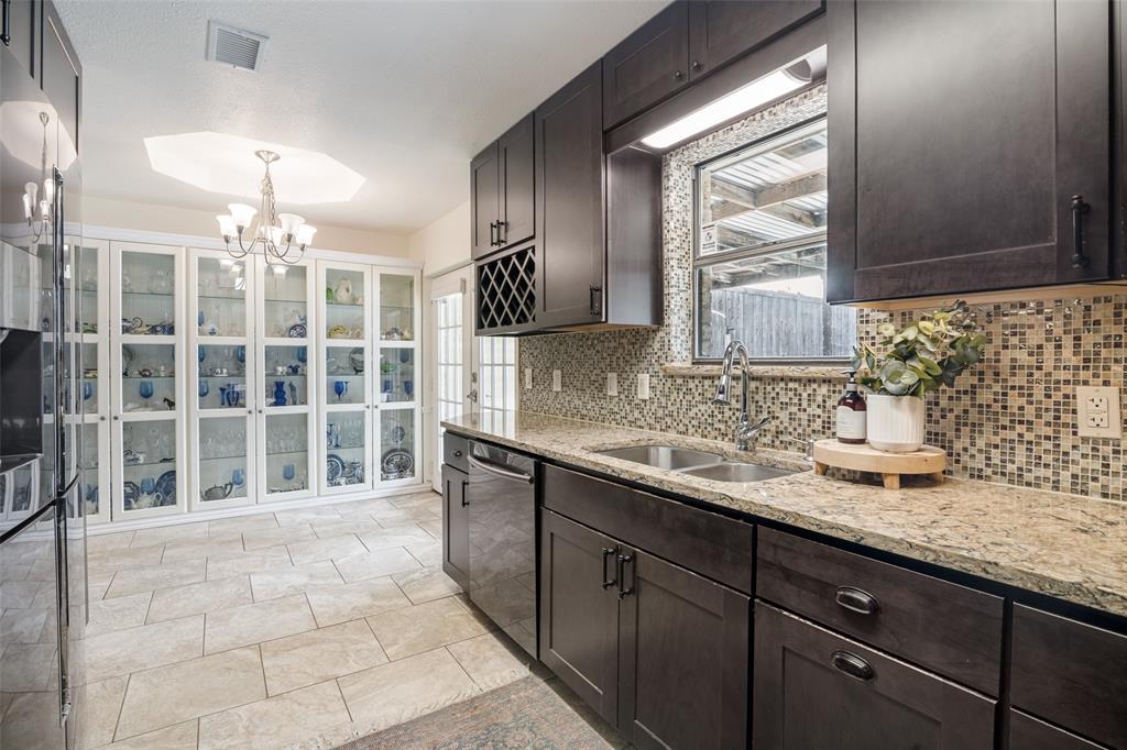 7706 Swiss Way Rowlett, TX 75089 - Photo 9 of 21 Updated kitchen featuring granite countertops, dark cabinetry with adjoining dining space.