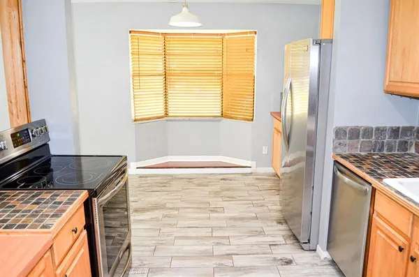 a bathroom with a granite countertop sink and a window