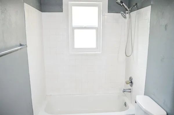 a bathroom with a bath tub with a shower