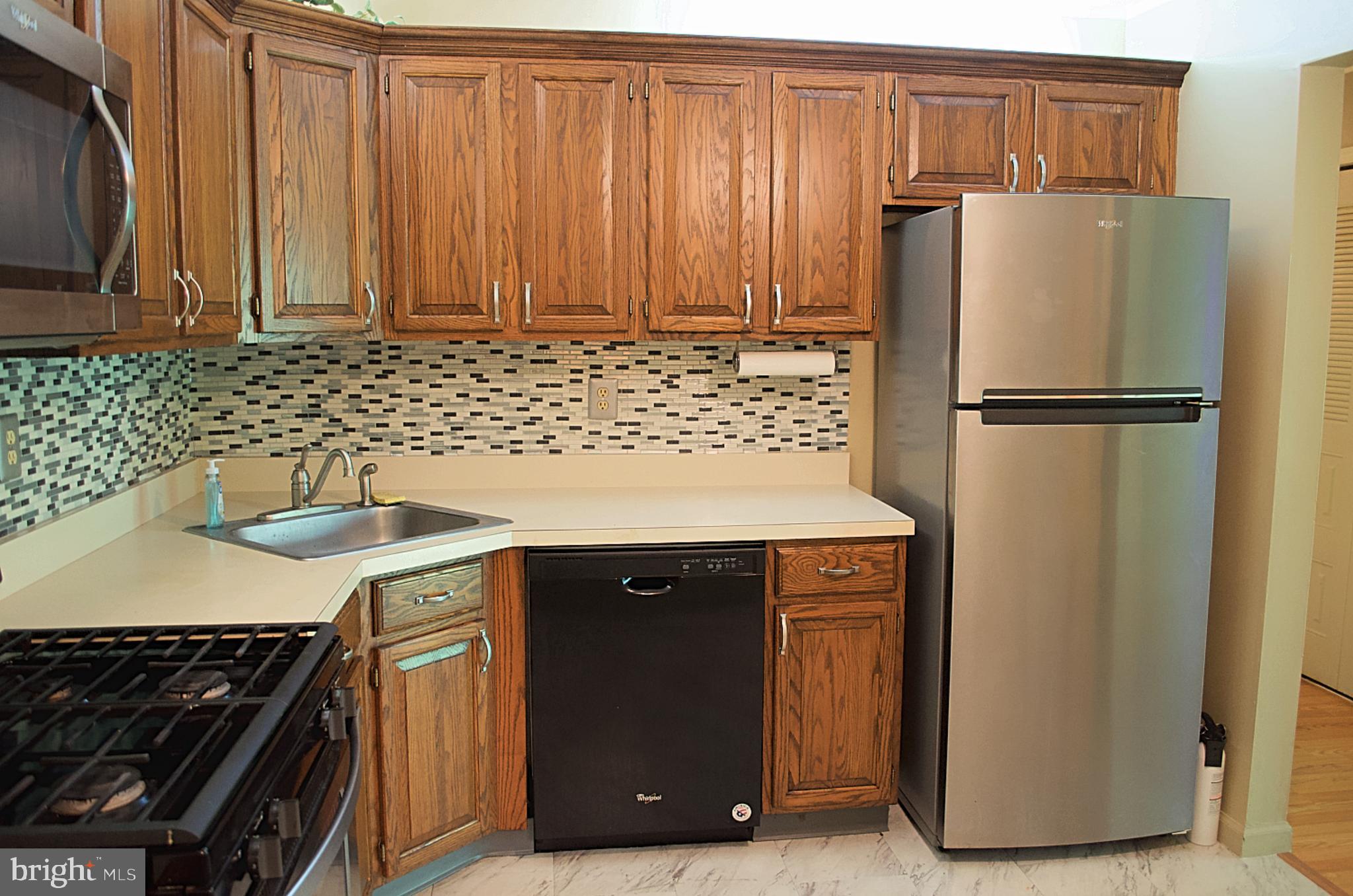 84 Willow Court Hamilton, NJ 08619 - Photo 4 of 18 a kitchen with a refrigerator and a sink