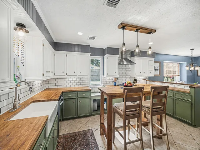 a kitchen with a sink a counter space appliances and cabinets