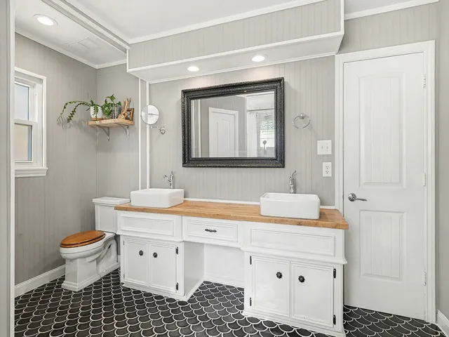 a bathroom with a sink toilet a mirror and shower