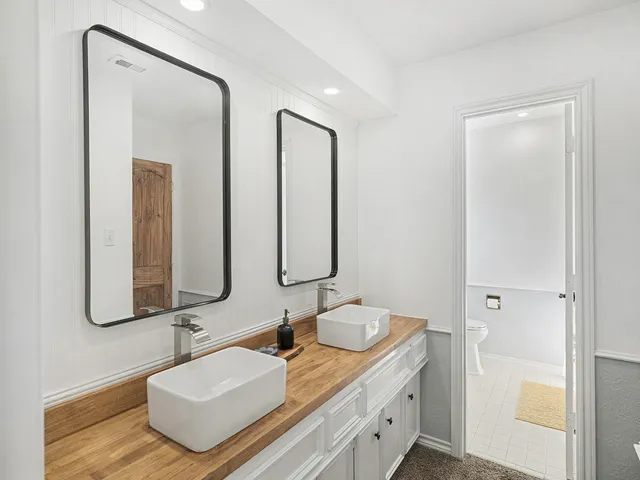 a bathroom with double vanity sinks and a mirror