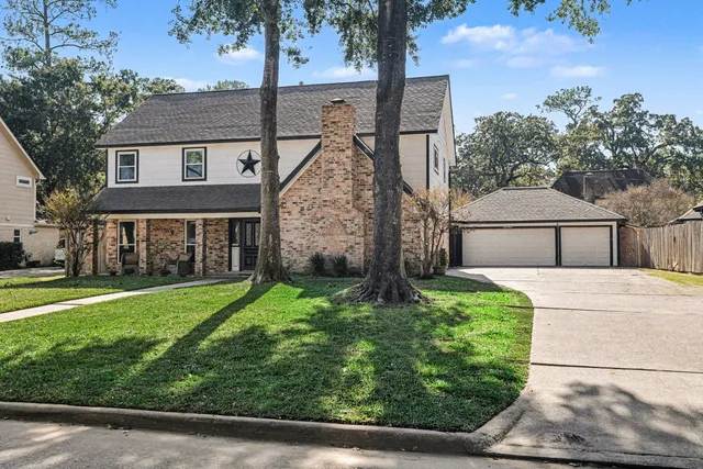 a view of house with a yard and potted plants