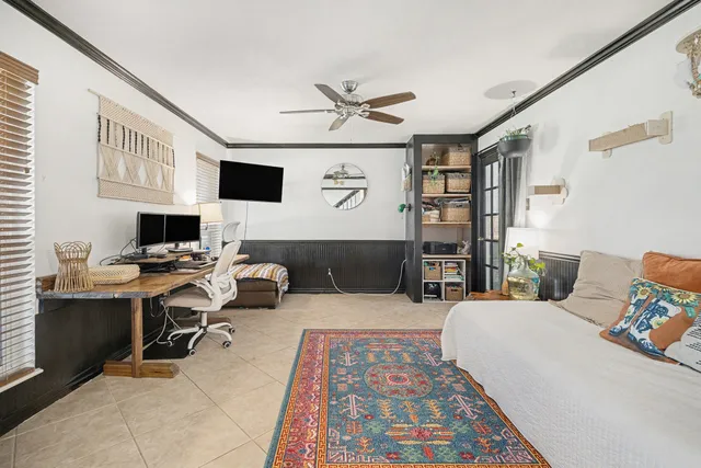 a bedroom with a bed wooden floor and a flat screen tv