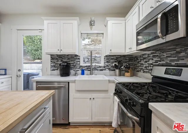 a kitchen with cabinets appliances and a window