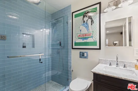 a bathroom with a granite countertop sink toilet and shower