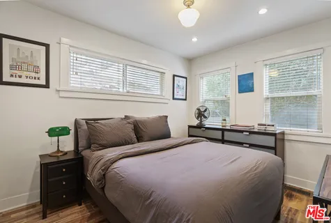 a bedroom with bed and tv on the dresser