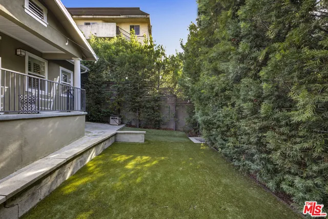 a view of a swimming pool with potted plants and large tree