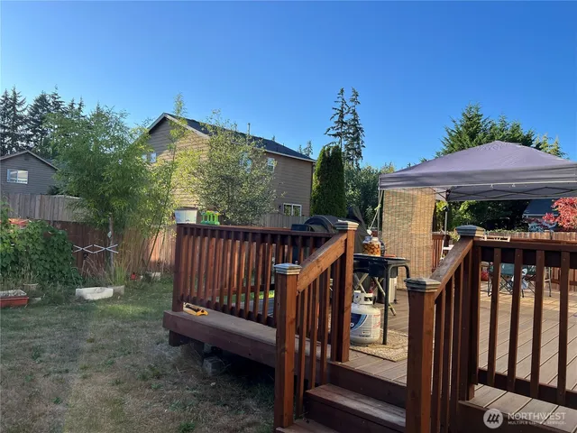 a view of a wooden deck in front of house with wooden fence