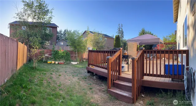 a view of a house with wooden deck and furniture