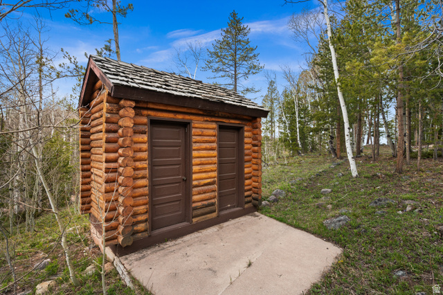 4725 Pine Ridge Road Evanston, UT 82930 - Photo 61 of 82 Log cabin structure with two entry doors and a wood shake roof