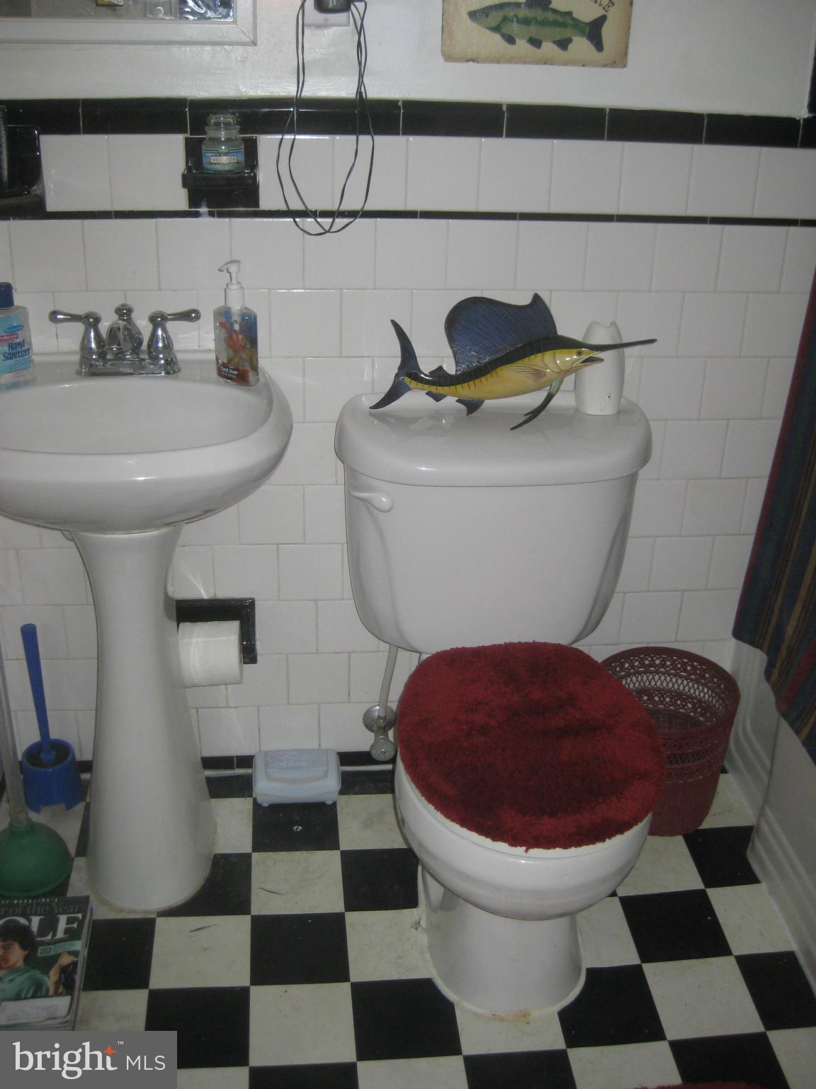 1117 Cedarcroft Road Baltimore, MD 21239 - Photo 9 of 11 a bathroom with a toilet a sink and a mirror