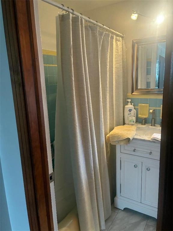 1238 Love Street Pittsburgh, PA 15218 - Photo 7 of 16 a bathroom with sink a mirror a bathtub and shower