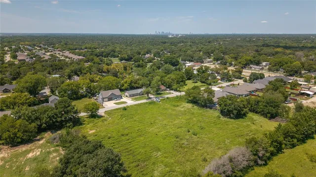 an aerial view of residential houses with outdoor space and trees